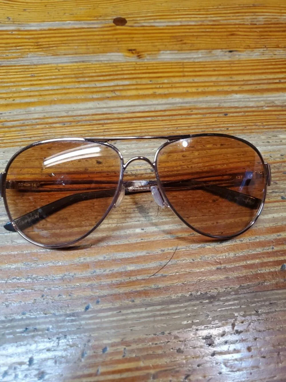 Oakley Caveat aviator sunglasses featuring a rose gold metal frame and warm brow